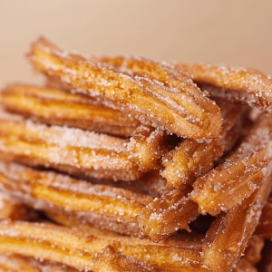A large stack of extra crispy churros covered in sugar and cinnamon