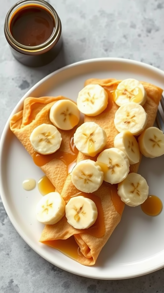 Plate of banana and peanut butter crepes topped with banana slices and drizzled with syrup