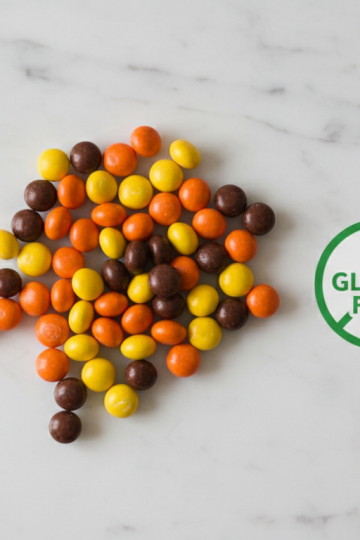 Reese's Pieces candy scattered on white marble with gluten-free badge