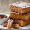 Churro French toast stack on white plate, cinnamon sugar coated brioche slices with chocolate dipping sauce