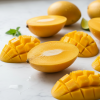 fresh ripe yellow mangoes cut in half showing bright orange flesh